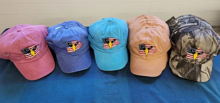 Three hats are sitting on a blue blanket.