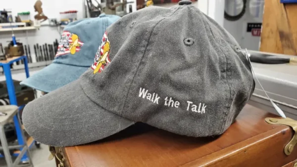 A gray hat with the words " walk the talk ".